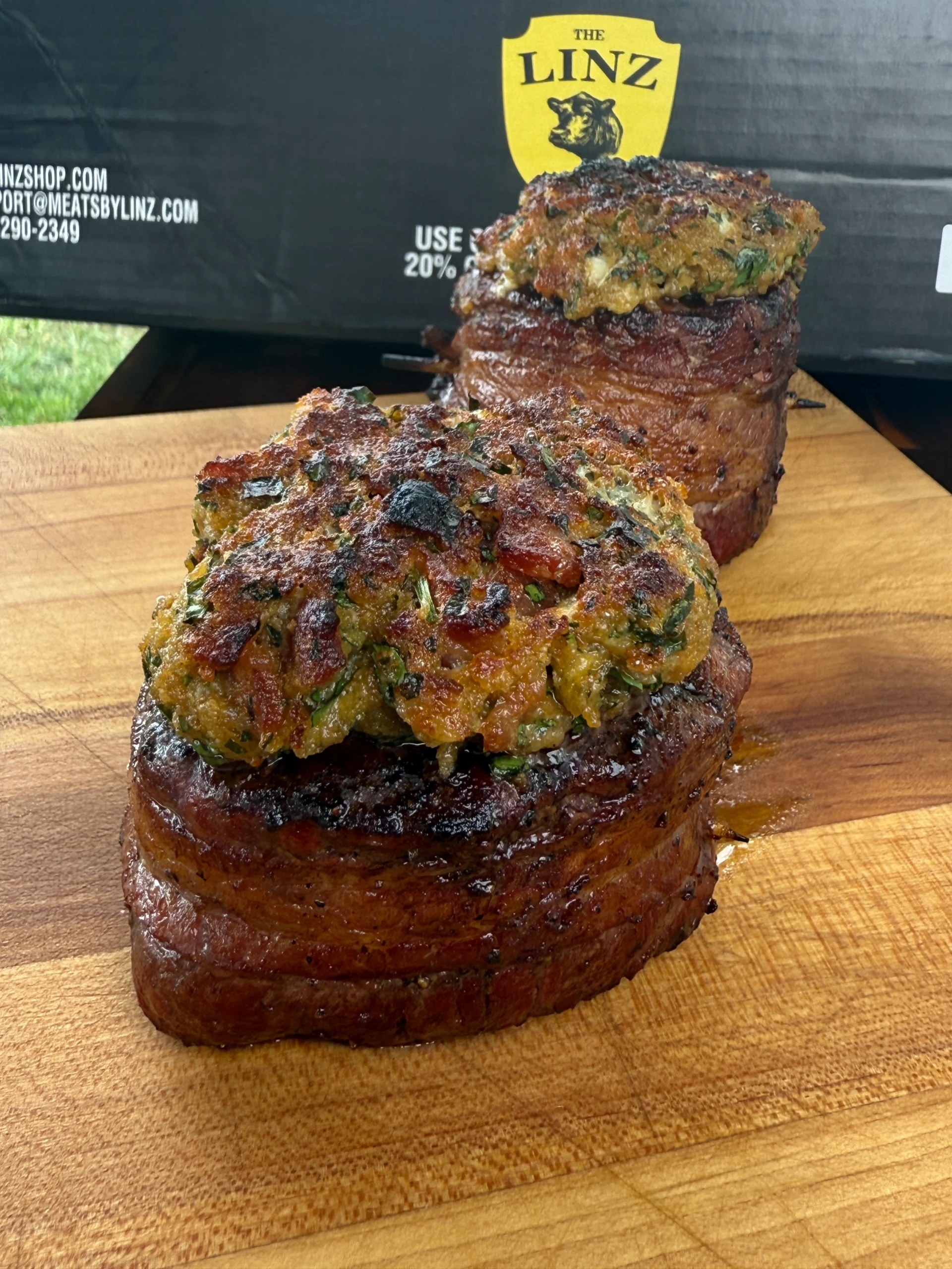 bacon wrapped filets on a cutting board with linz meats