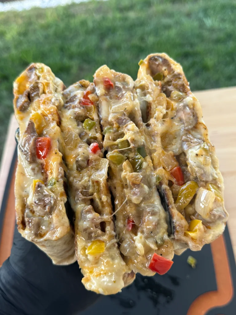 Cooked crunchwrap cut in half showing layers of steak, vegetables, and cheese