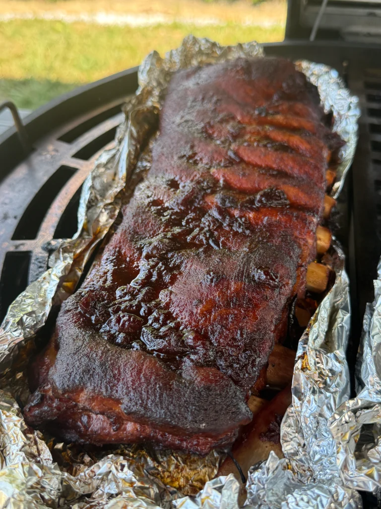 Steam rising from unwrapped ribs after Texas crutch method in Cherry Dr Pepper glazed ribs recipe
