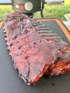 Finished Cherry Dr Pepper glazed ribs resting on cutting board with caramelized glaze and perfect color