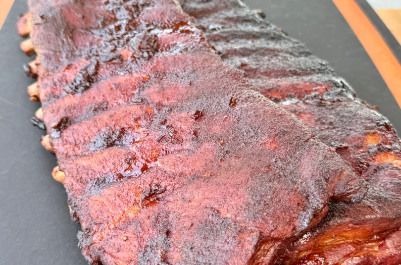 Finished Cherry Dr Pepper glazed ribs resting on cutting board with caramelized glaze and perfect color