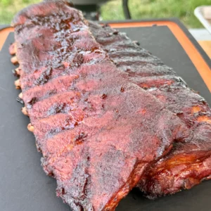 Finished Cherry Dr Pepper glazed ribs resting on cutting board with caramelized glaze and perfect color