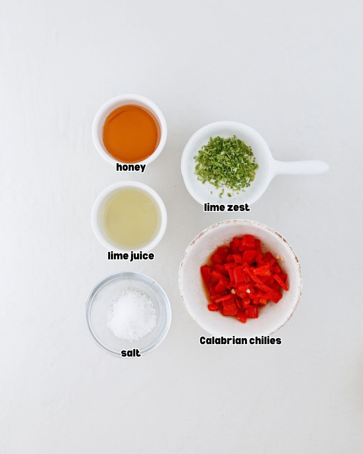 ingredients for chili lime ghee sauce placed in small bowls on a kitchen countertop.