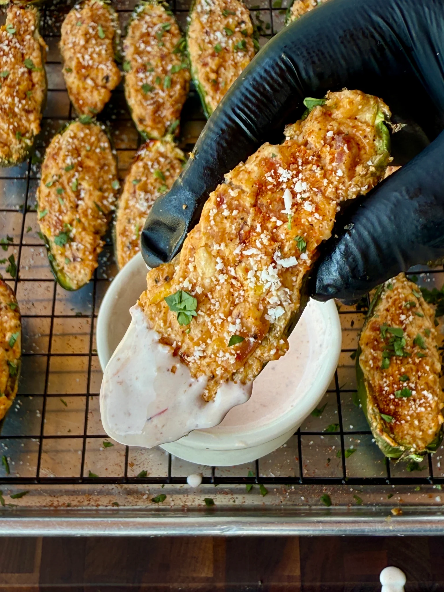 up close of a single jalapeno popper with sauce