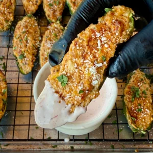 up close of a single jalapeno popper with sauce