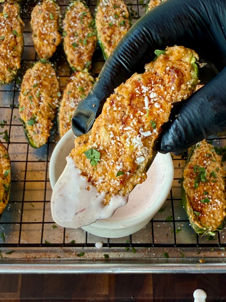 up close of a single jalapeno popper with sauce