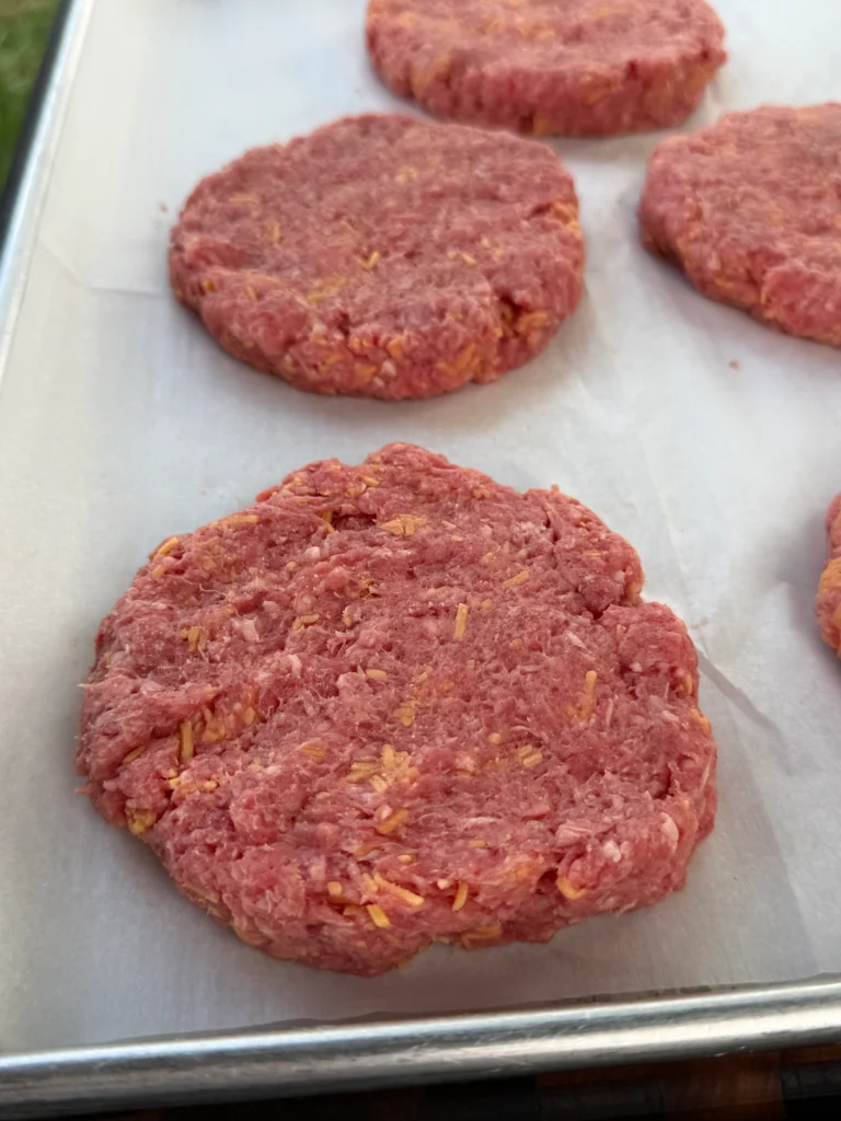 ground beef made into patties on parchment paper