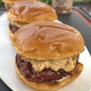 3 smoked finished cheese burgers on a plate