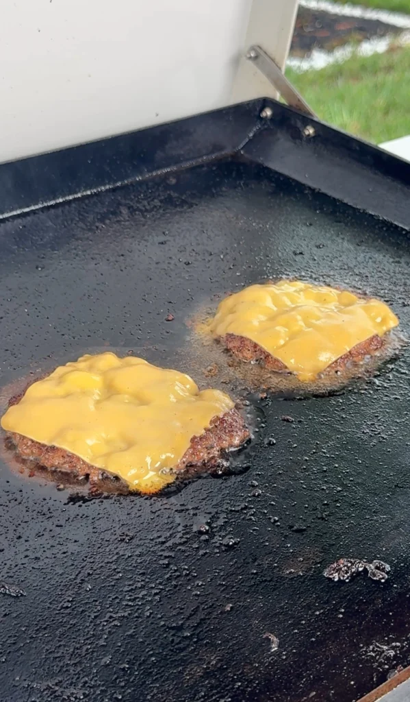 cheesed smash burgers on the griddle