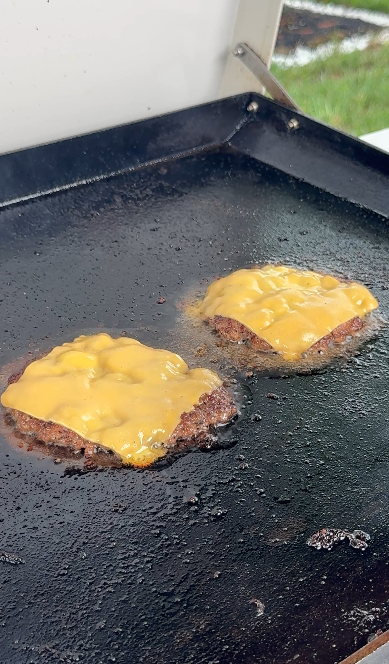 cheesed smash burgers on the griddle