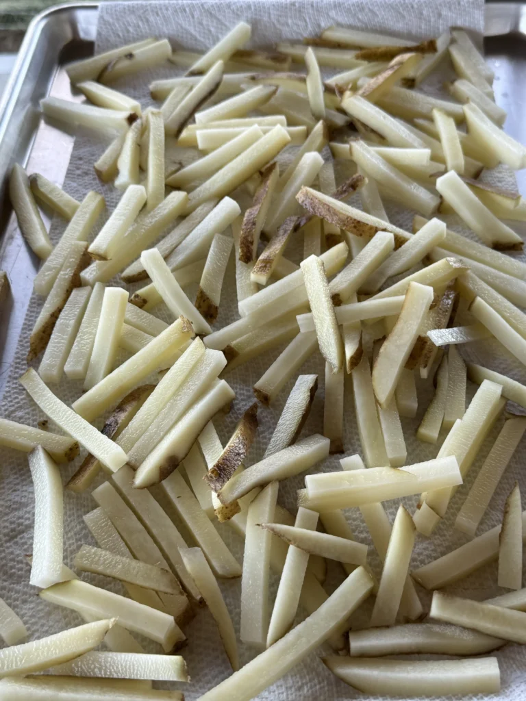 french fries on a board resting before frying