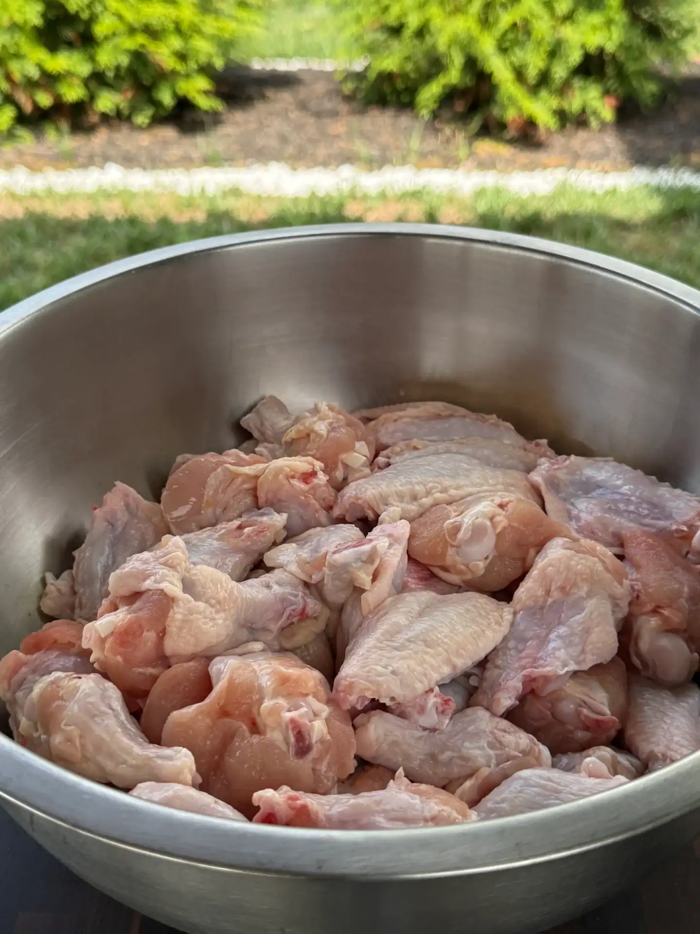 raw chicken wings in a stainless steel bowl.