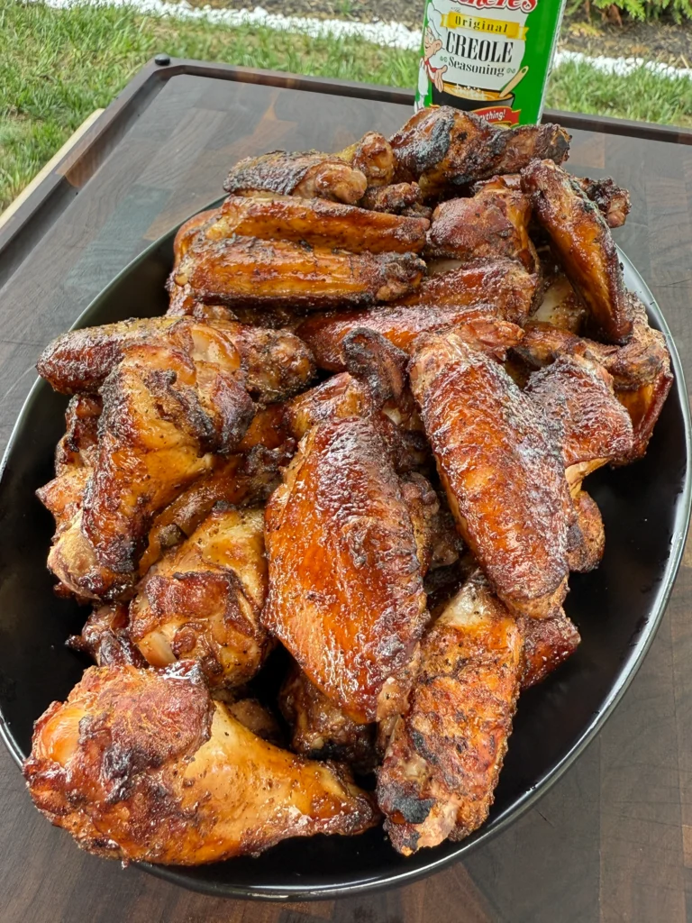 Overhead view of smoked and grilled Creole chicken wings with Tony's ranch dip with Southern garnishes