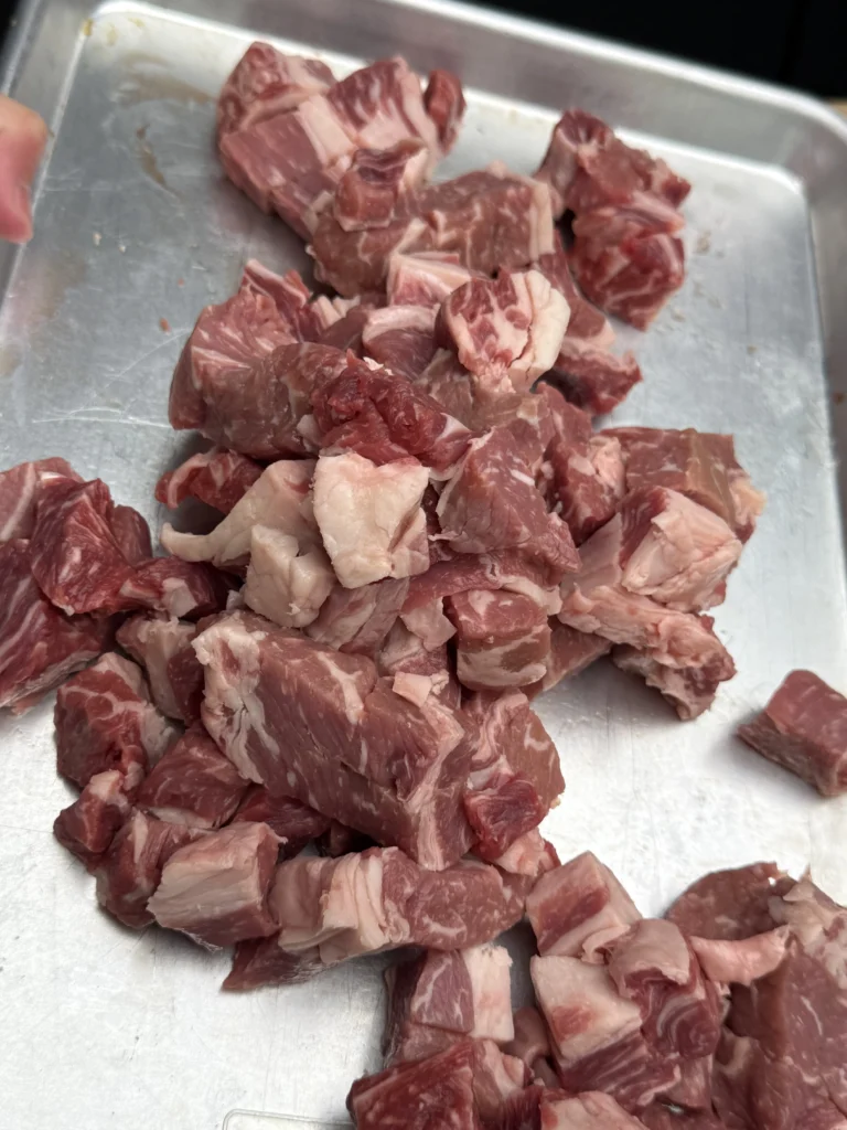 unseasoned steak bites on a metal tray