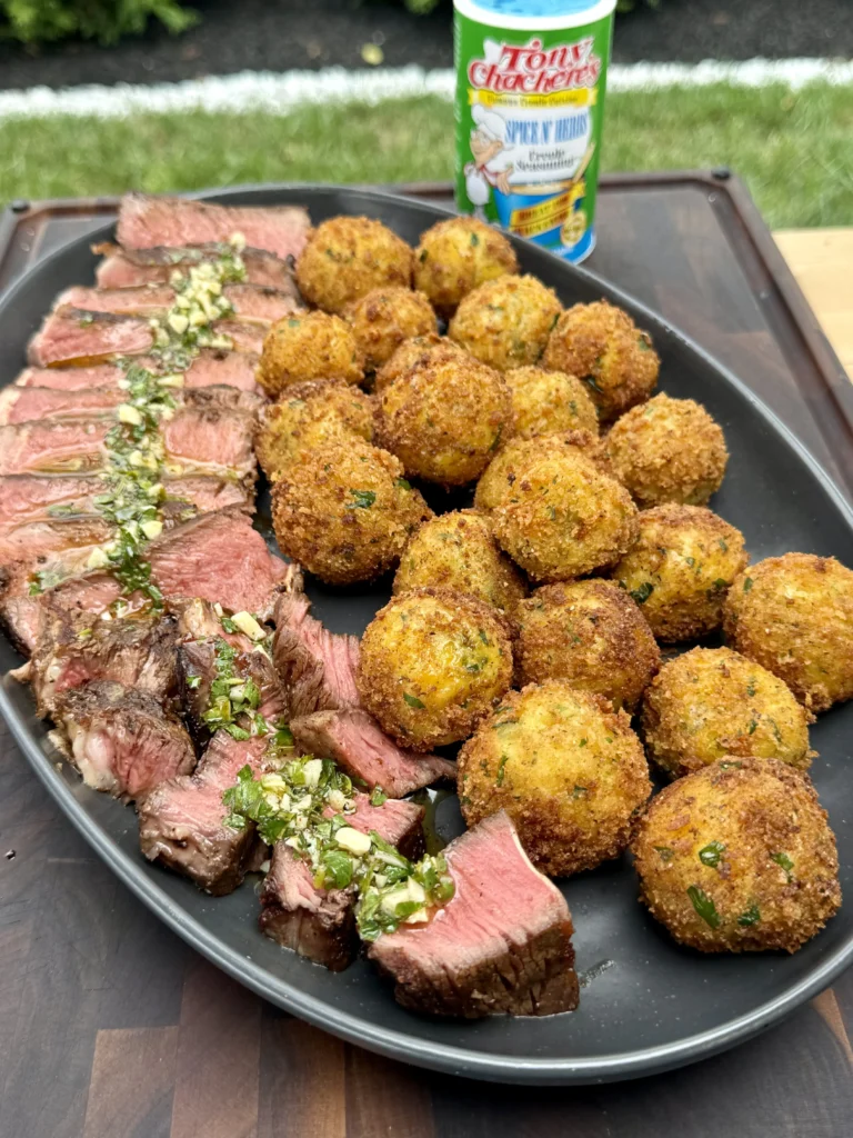 Final presentation of blackened Cajun ribeye slices with herb butter and golden potato croquettes, showcasing the complete restaurant-quality steakhouse experience