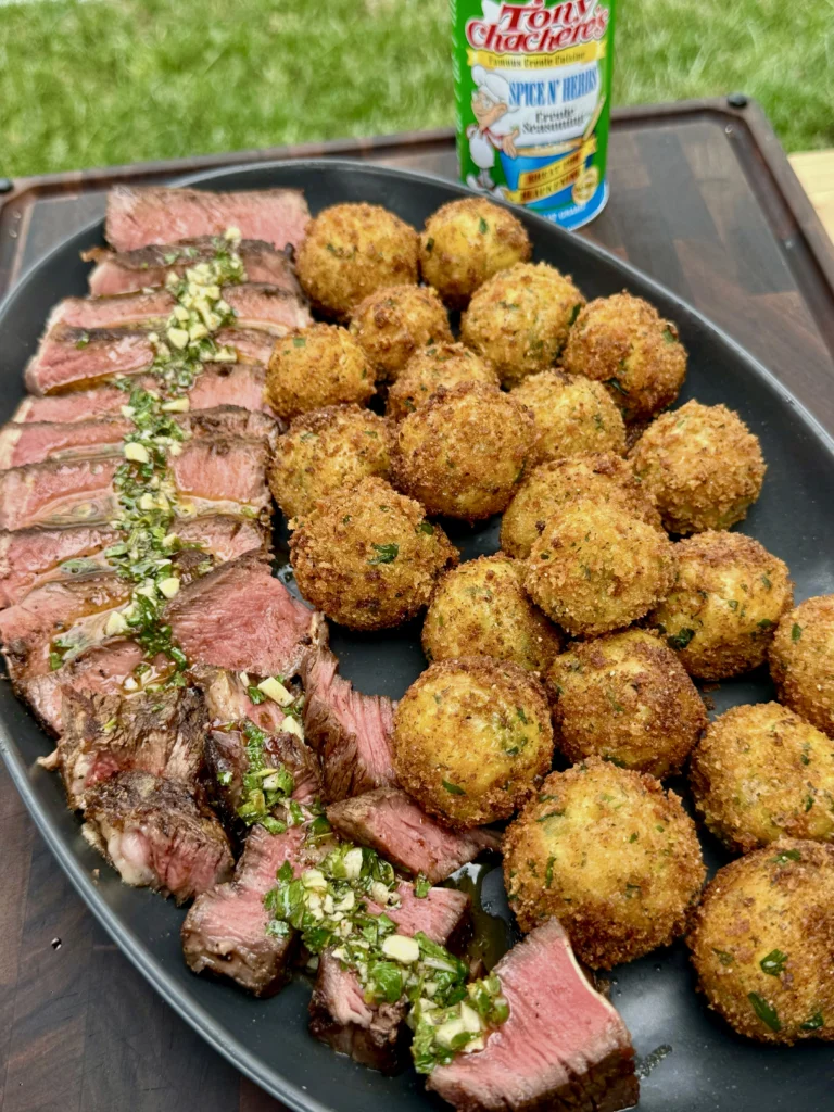 Different angle of plated ribeye slices with herb butter and golden croquettes, showing restaurant-quality presentation with seasoning bottle