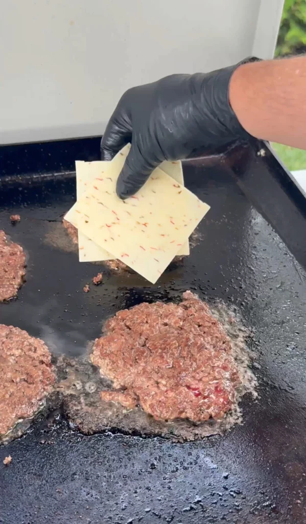 burgers with cheese being added to it