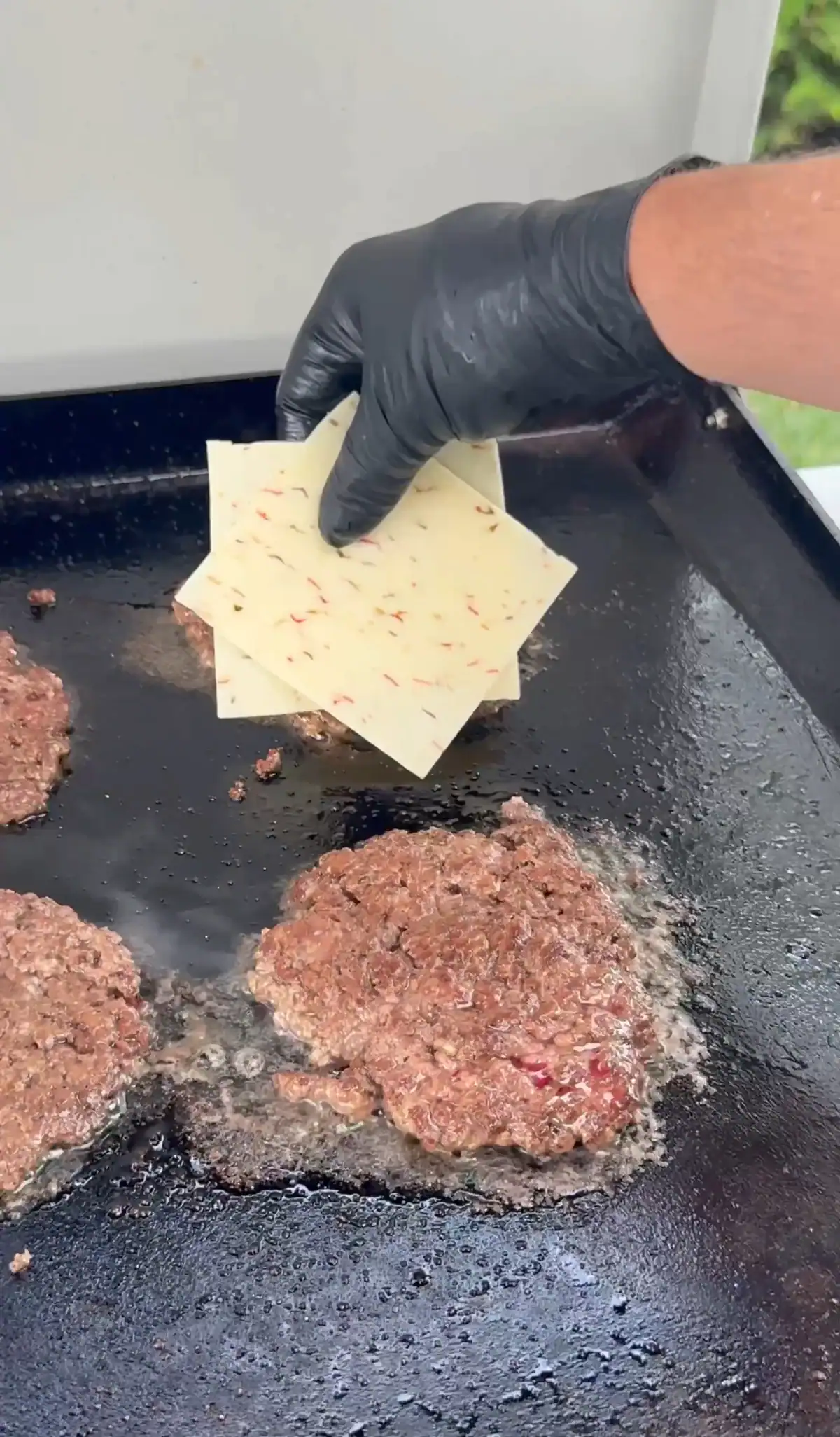 burgers with cheese being added to it
