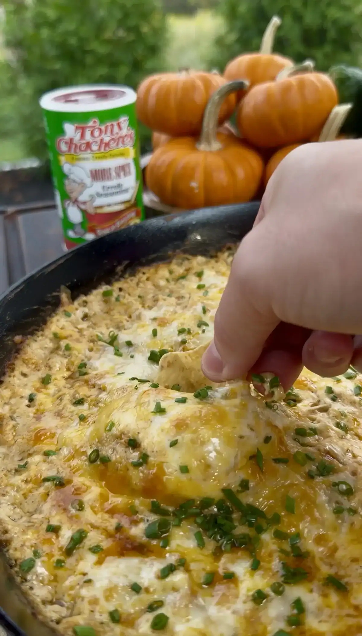 scooping buffalo chicken dip in a a cast iron
