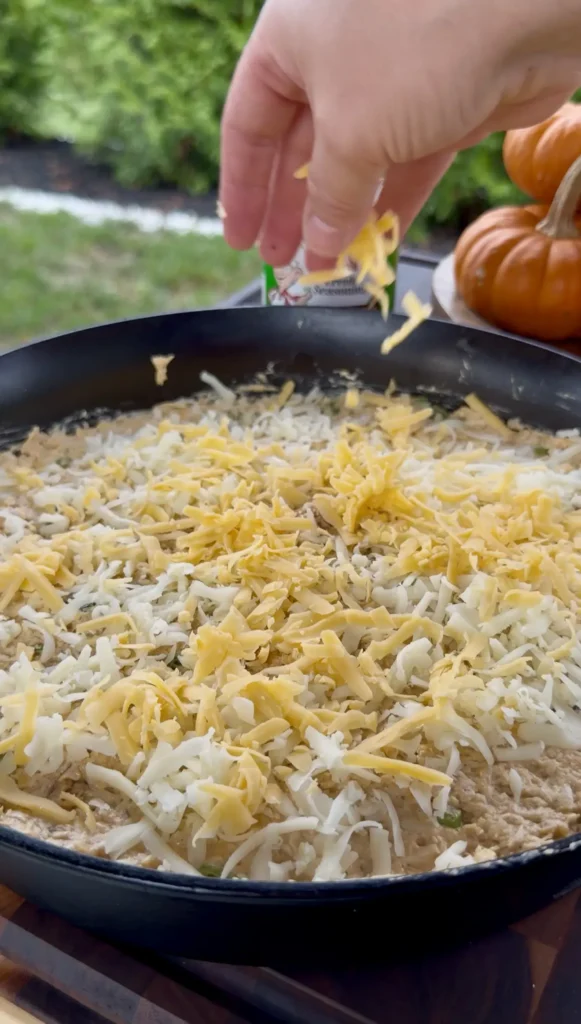 adding cheese to the buffalo chicken dip mix
