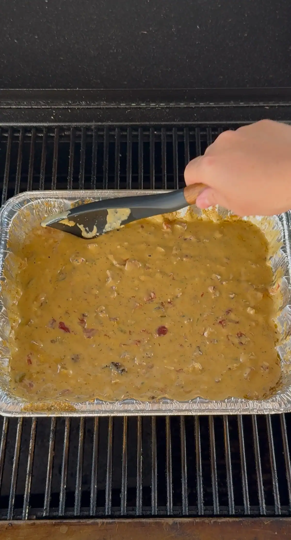mixing the queso up on the smoker