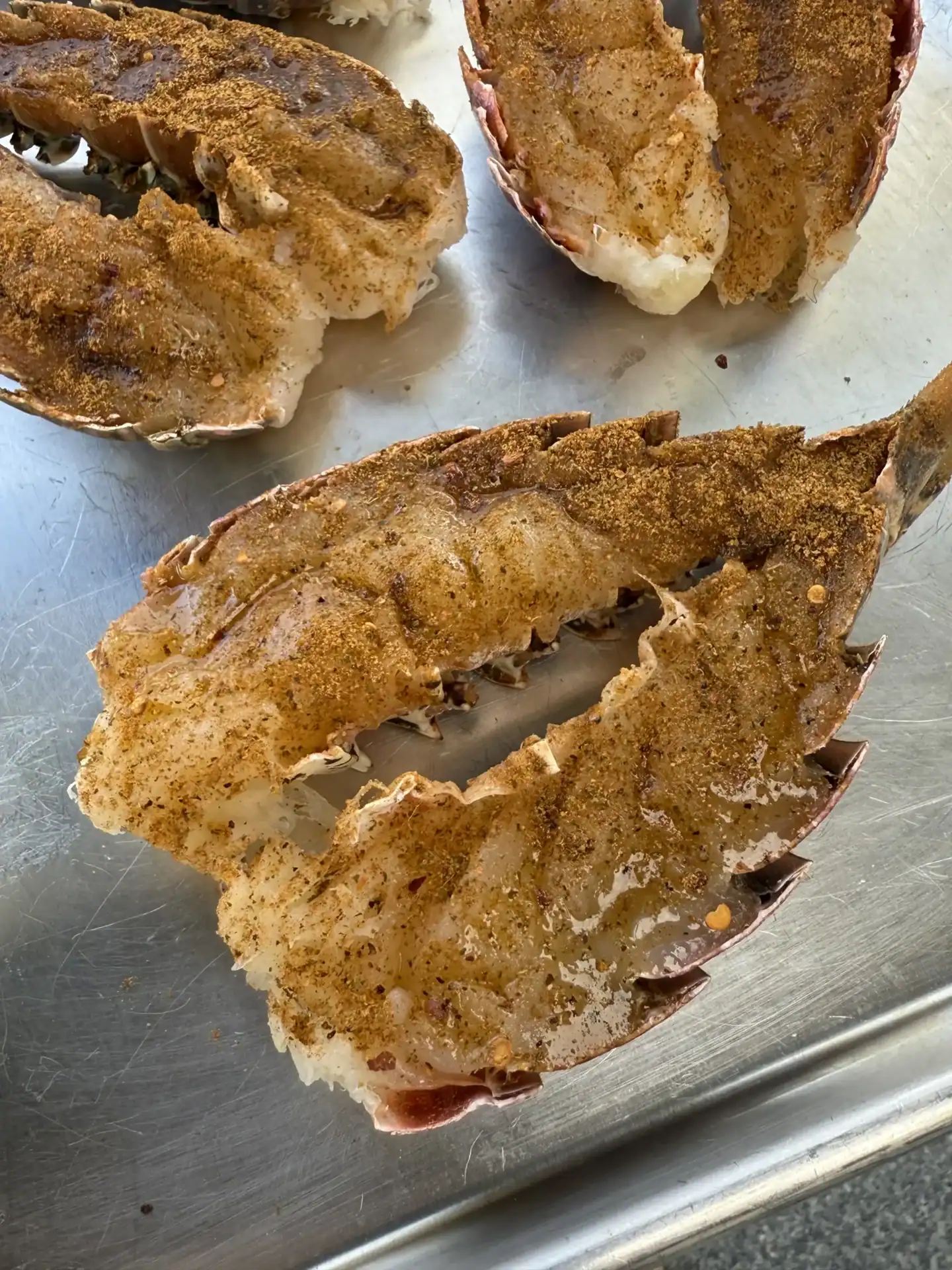 seasoned lobster tails on a silver tray