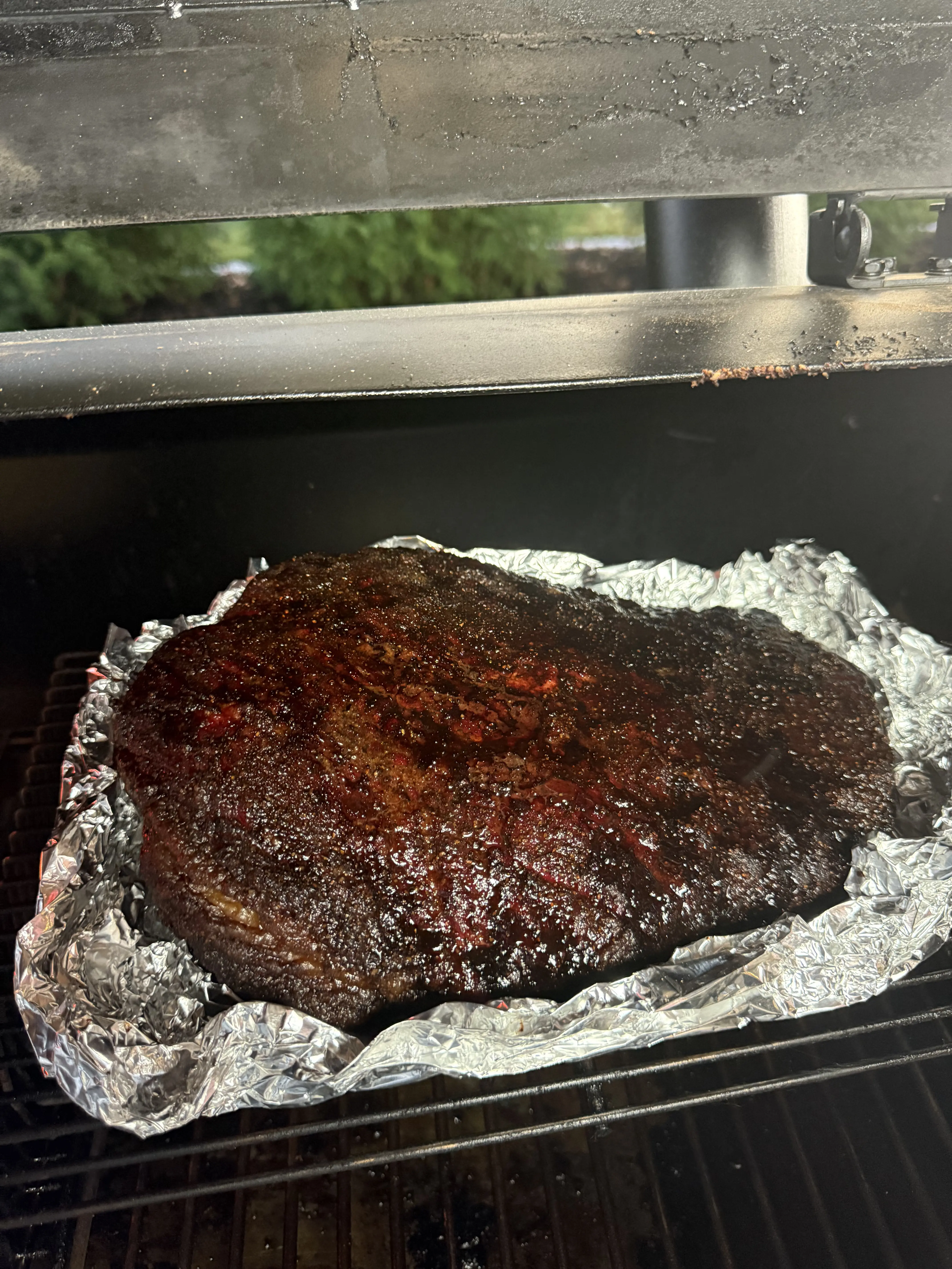Brisket being wrapped in butcher paper on the pellet smoker