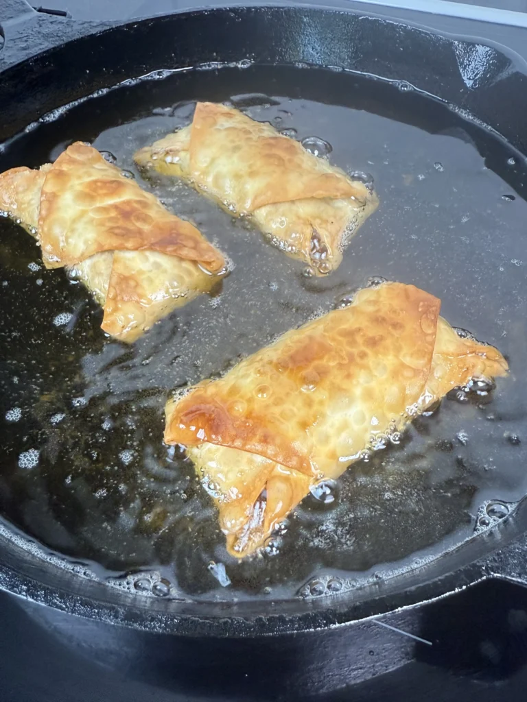 frying the egg rolls in a cast iron skillet
