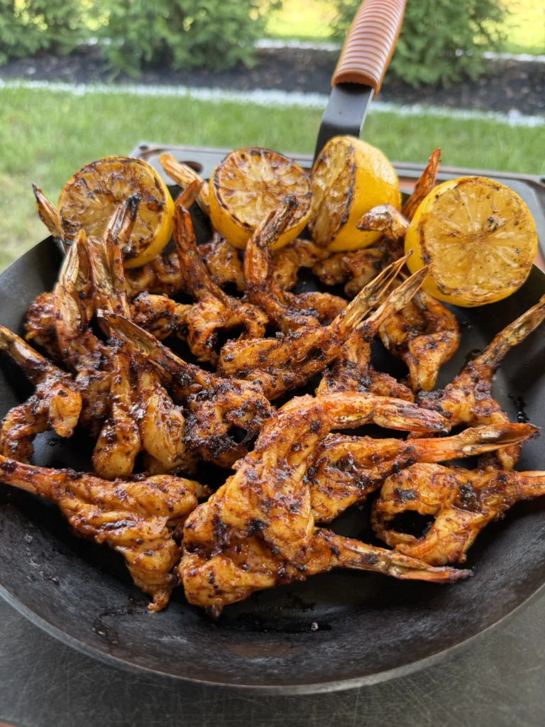 plate of grilled shrimp on a black plate