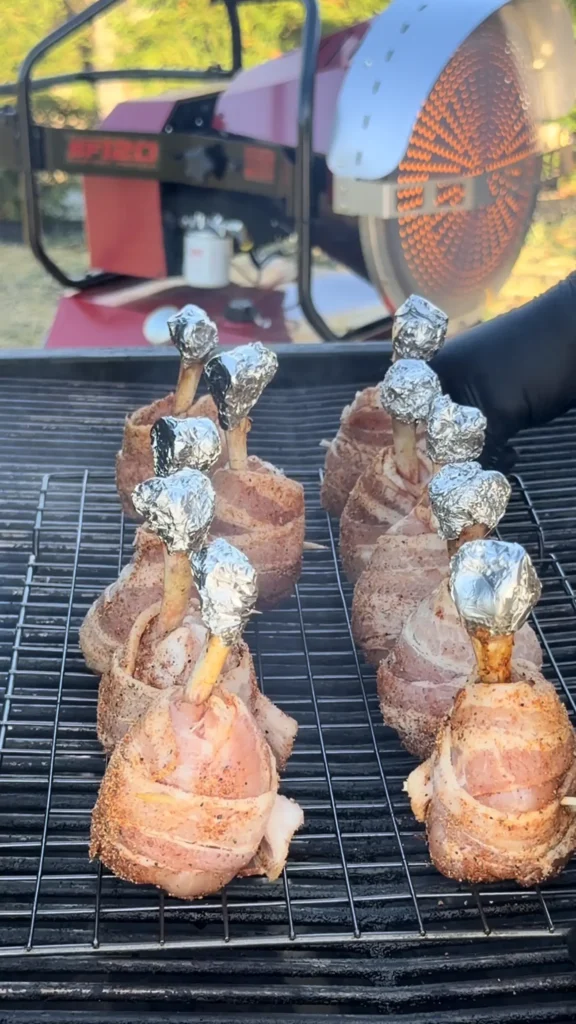 chicken lollipops in 2 rows on a hasty bake smoker
