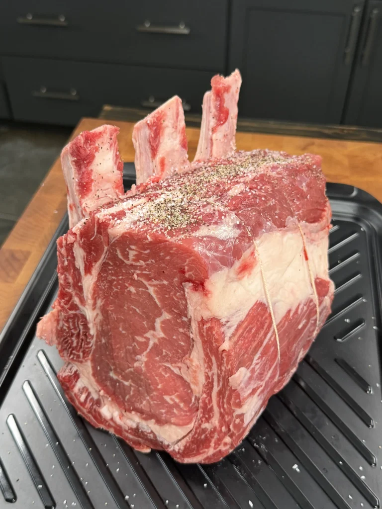 prepped prime rib on a black cutting board