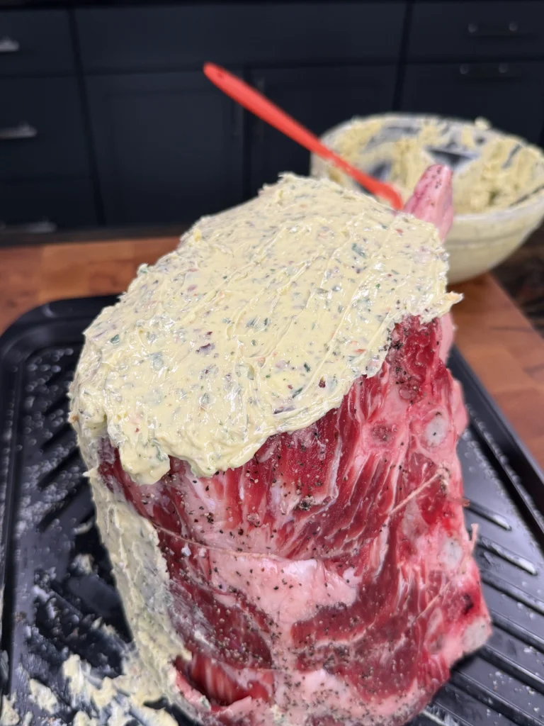 putting the herb butter on the prime rib roast