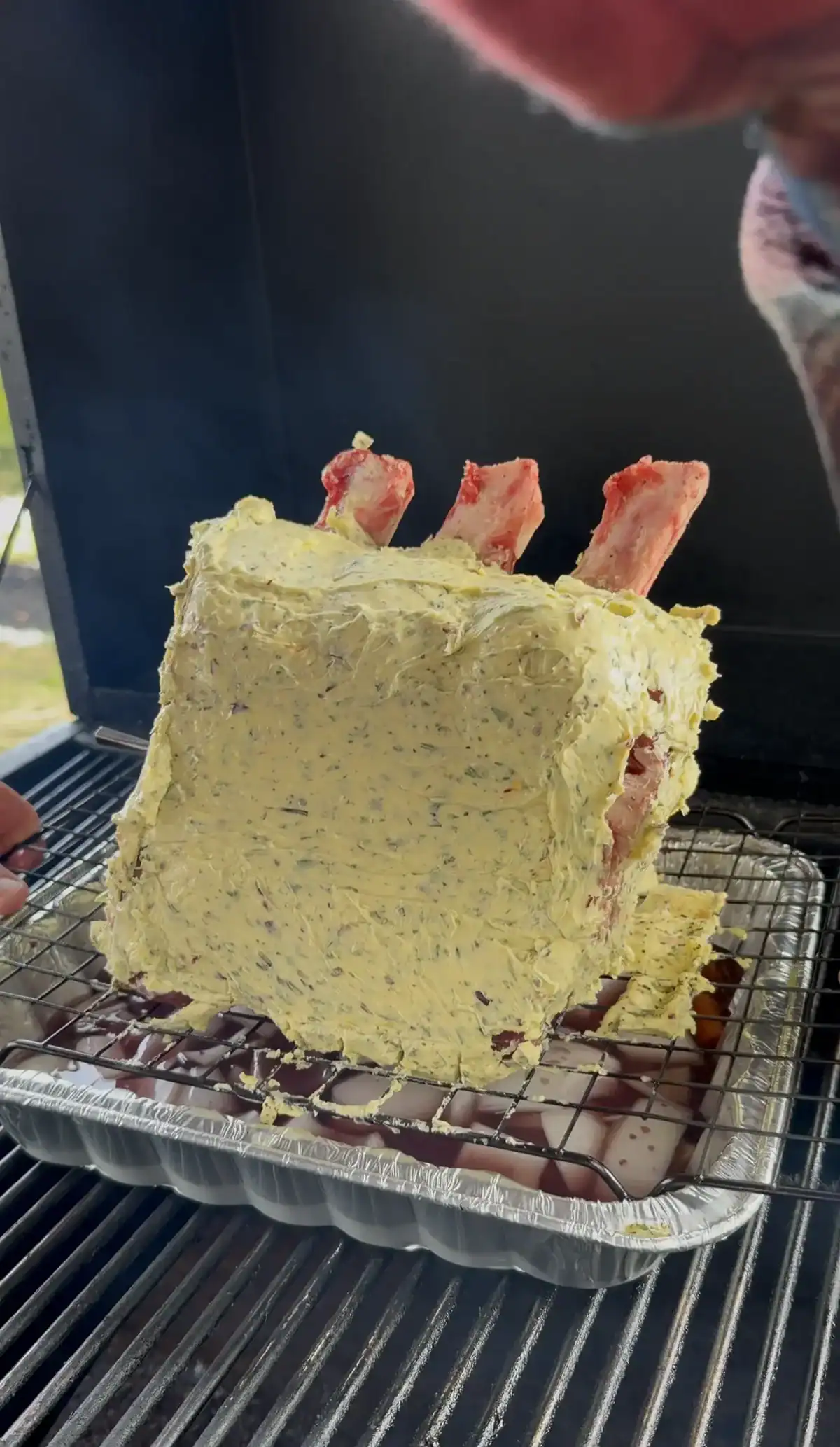 prime rib on the smoker with a drip pan underneath