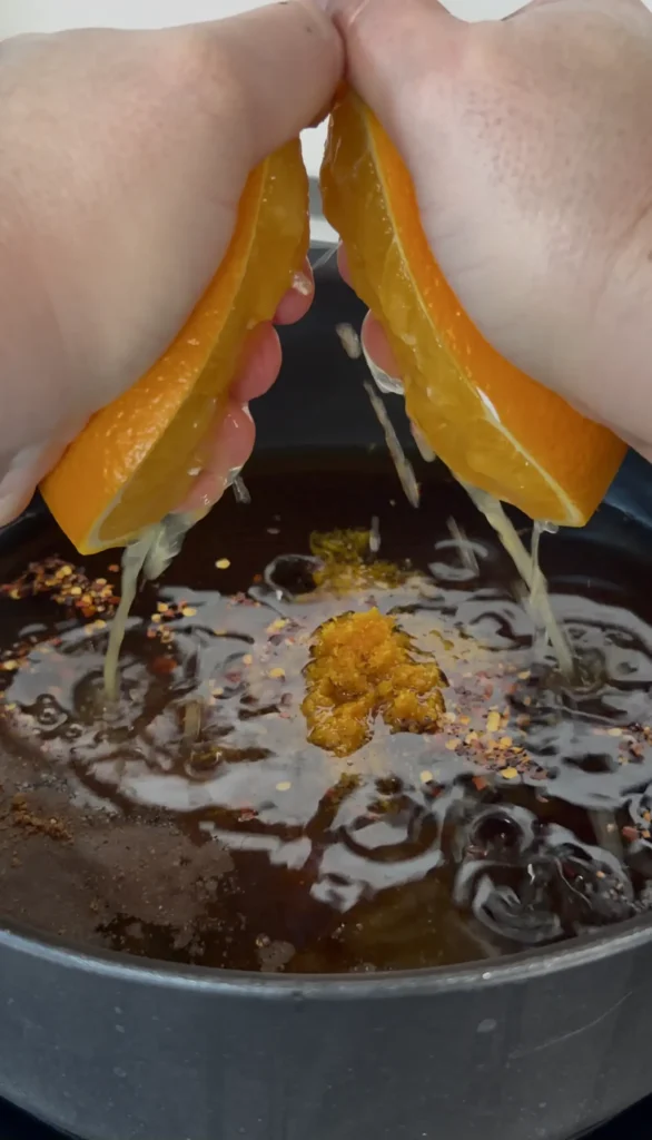 squeezing orange juice into the glaze