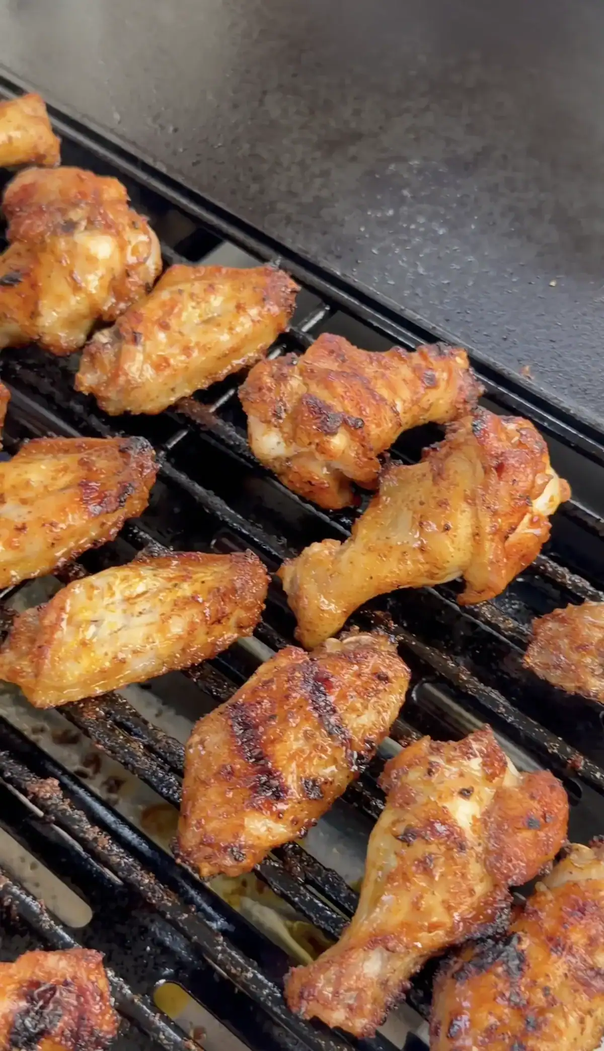 grilling chicken wings over charcoal