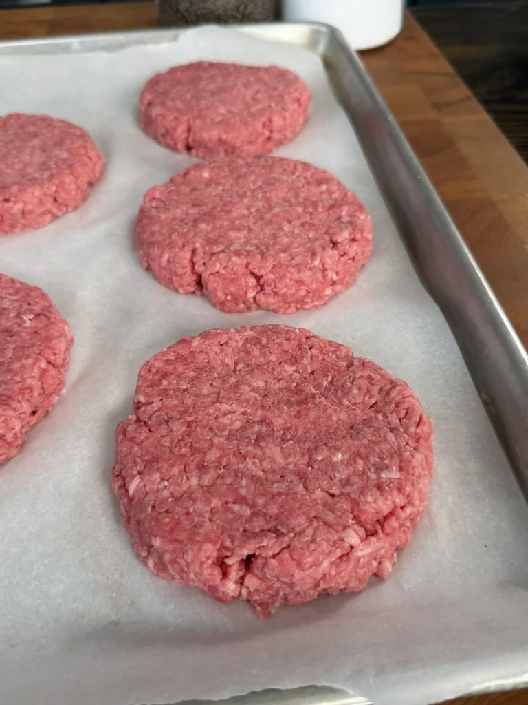 burger patties on a layer of parchment paper