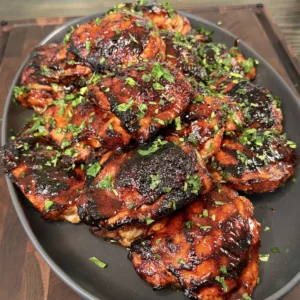 Plated chili lime grilled chicken thigh served alongside cilantro lime rice and fresh mango salsa