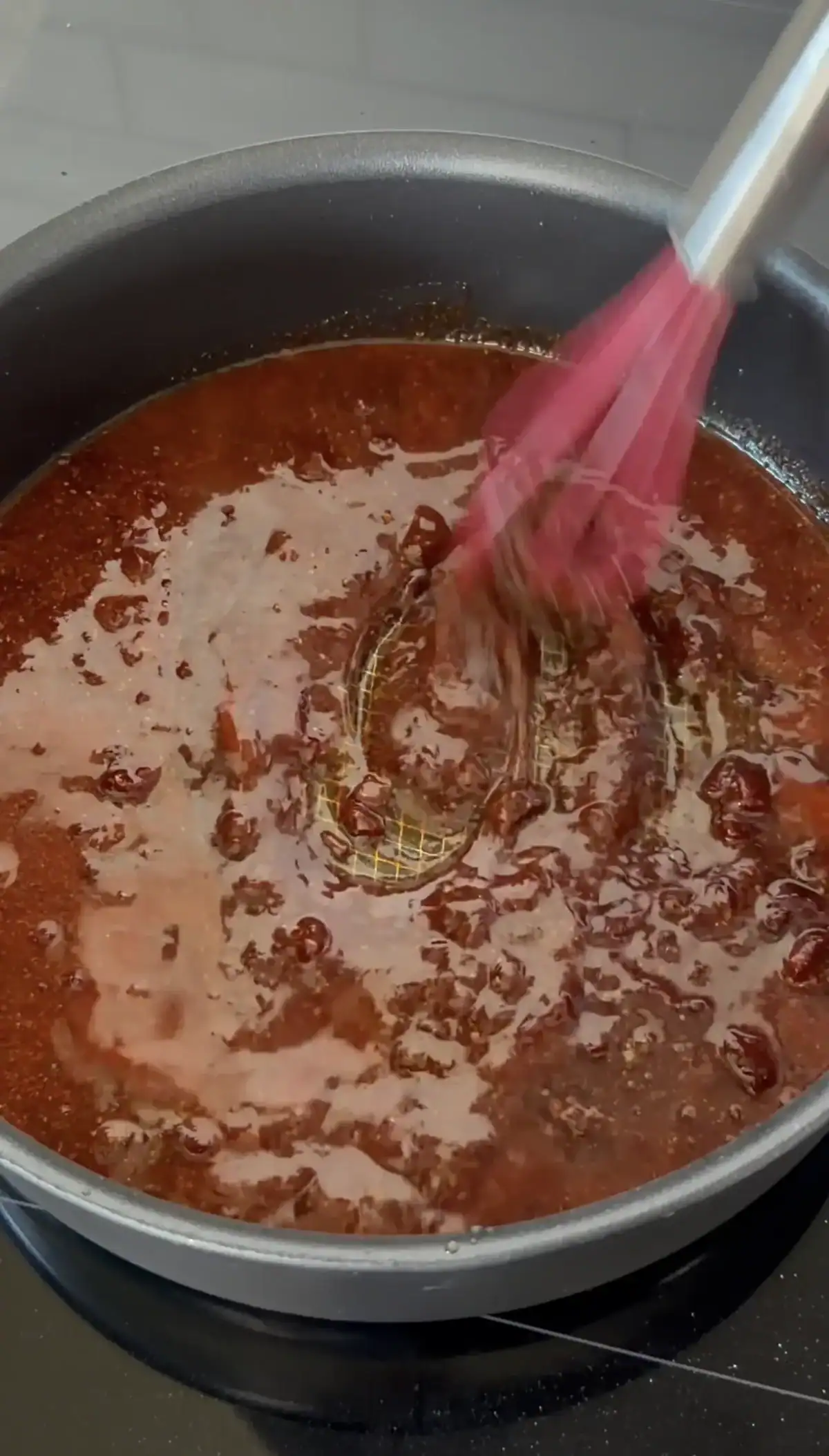 chicken wing sauce being whisked in a pot.