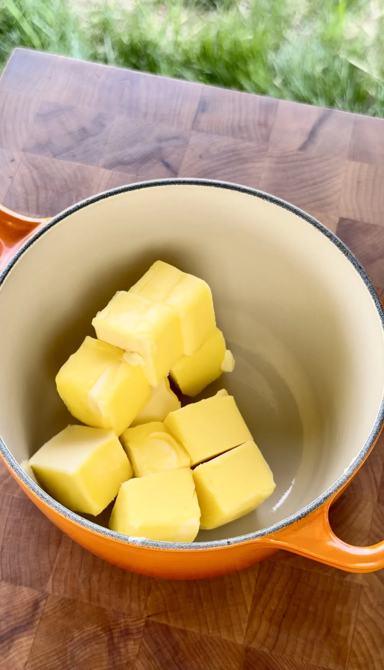 Butter cubes melting in an orange pot for garlic butter sauce