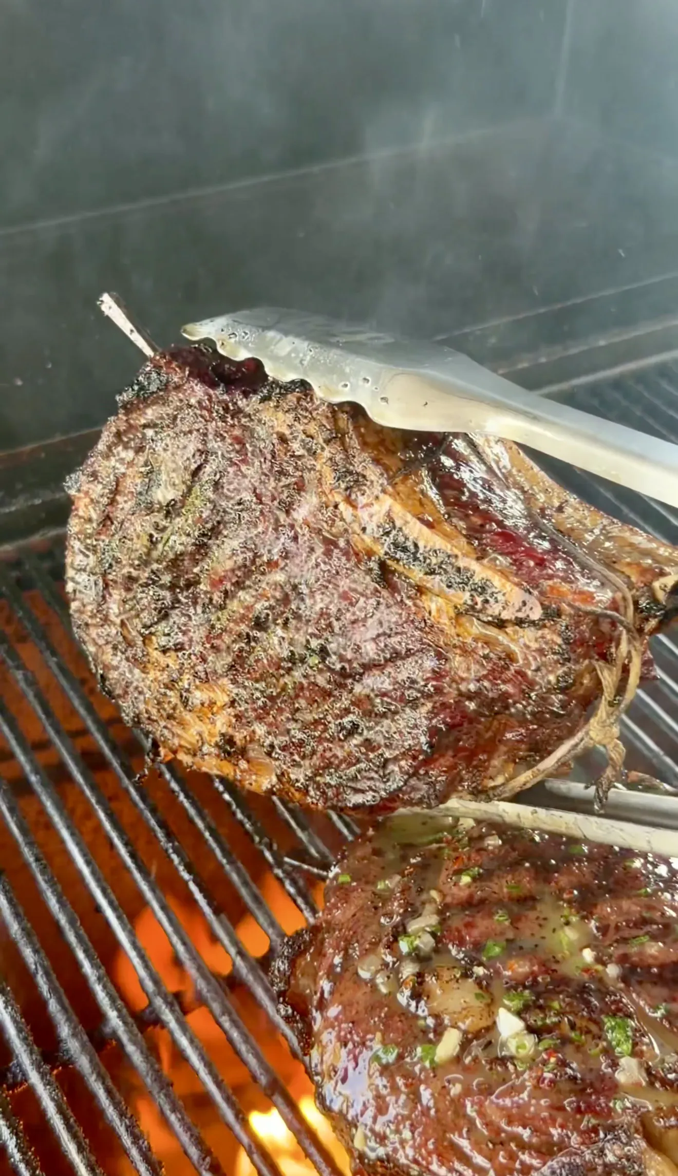 Grilled steaks with whiskey butter searing on a hot grill