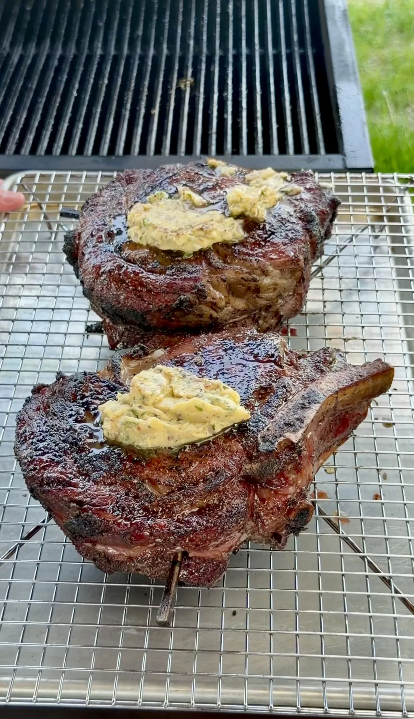 Grilled steaks with whiskey butter resting on a cooling rack