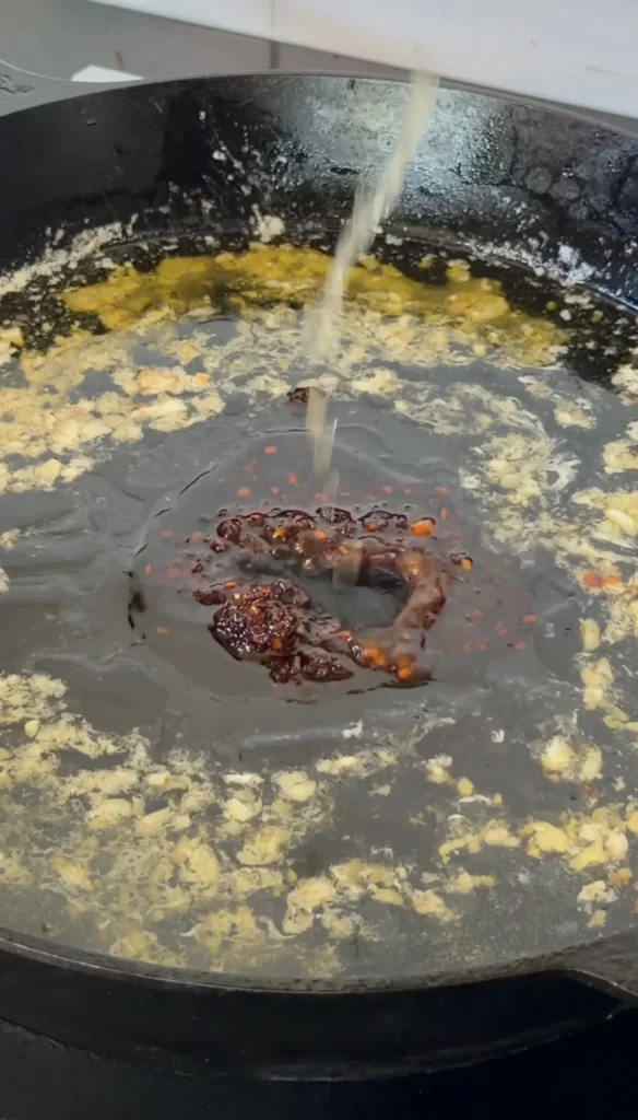 Fresh lobster meat cooking in a hot pan with melted honey butter sauce for lobster rolls