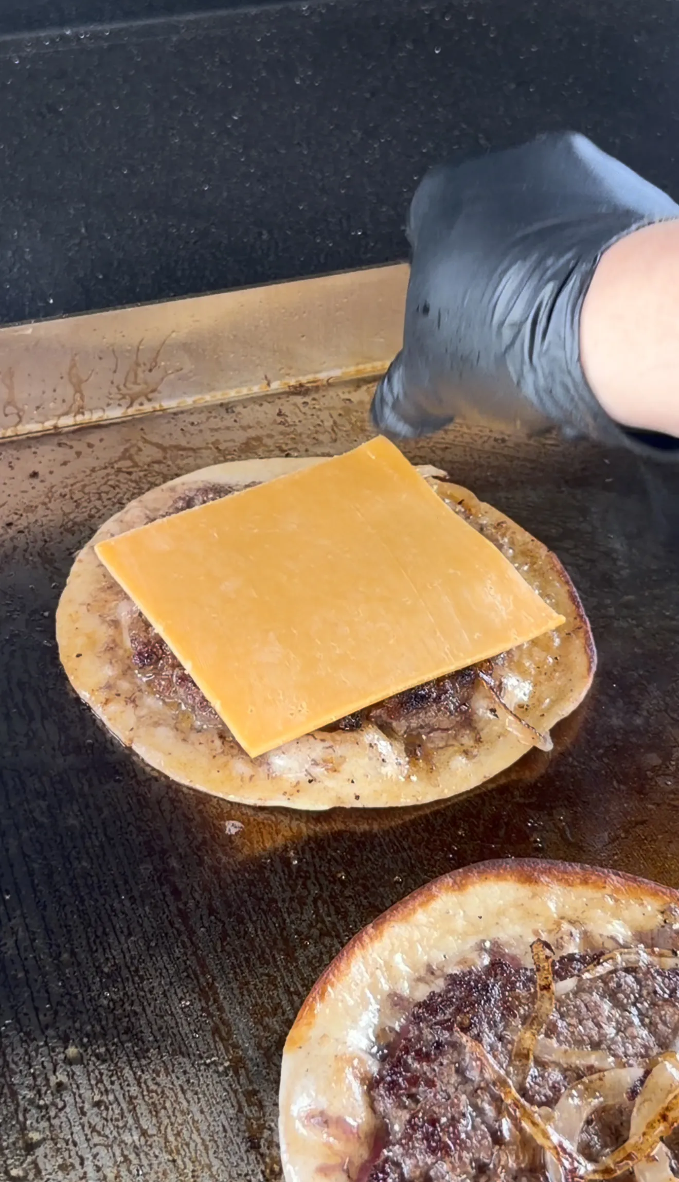 Oklahoma onion smash burger tacos cooking beef-side down on a hot griddle