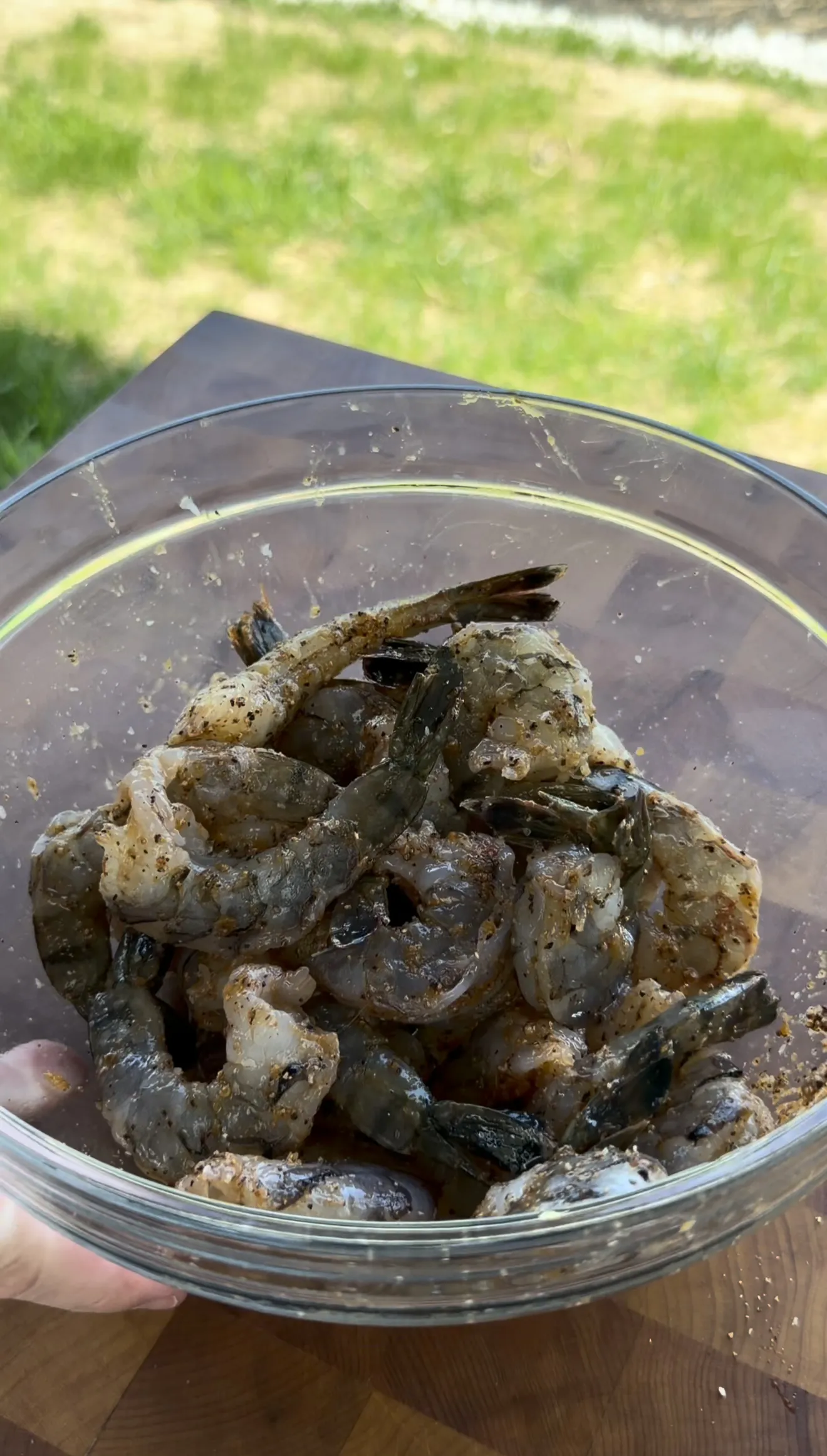 Raw marinated shrimp in a glass bowl coated with seasoning