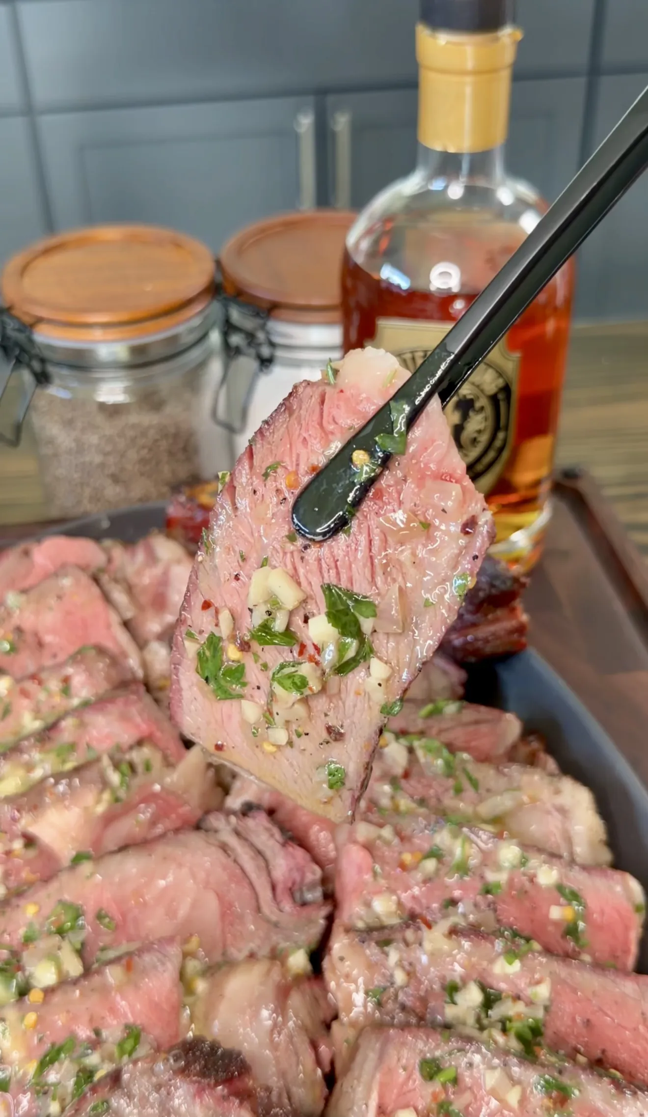 Marinated steaks with herbs and tongs on the grill