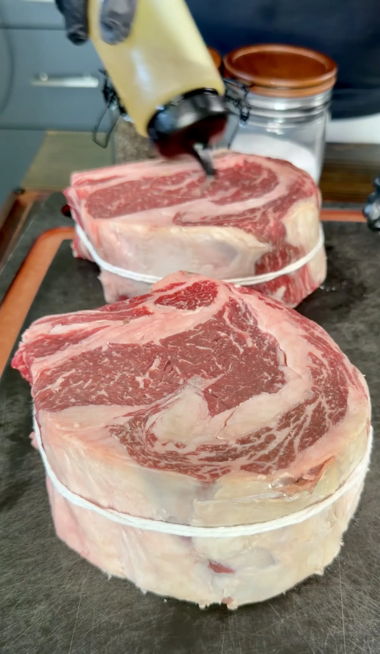 Raw ribeye steaks vacuum sealed on kitchen counter before preparation