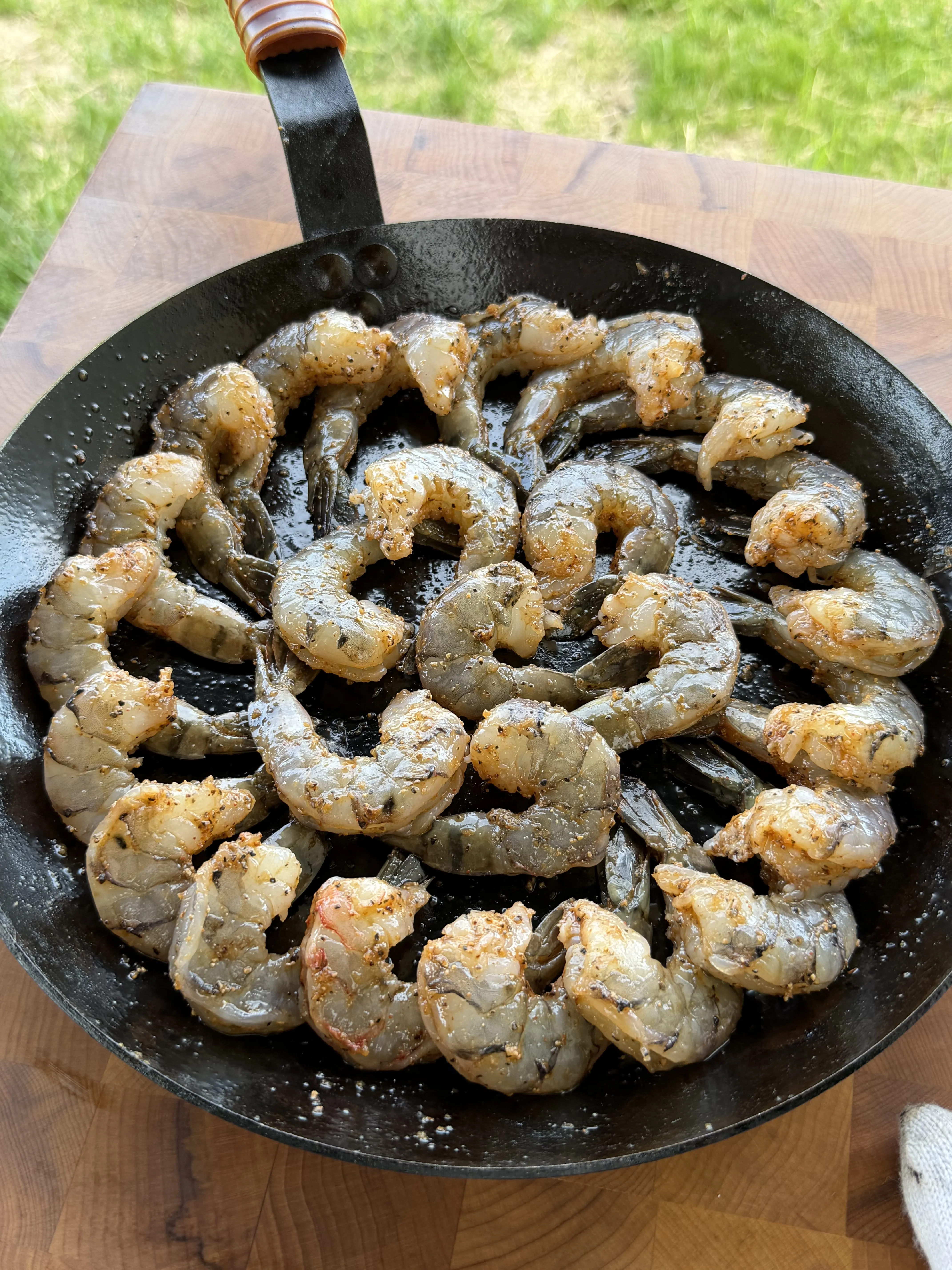 Seasoned raw shrimp arranged in a cast iron skillet