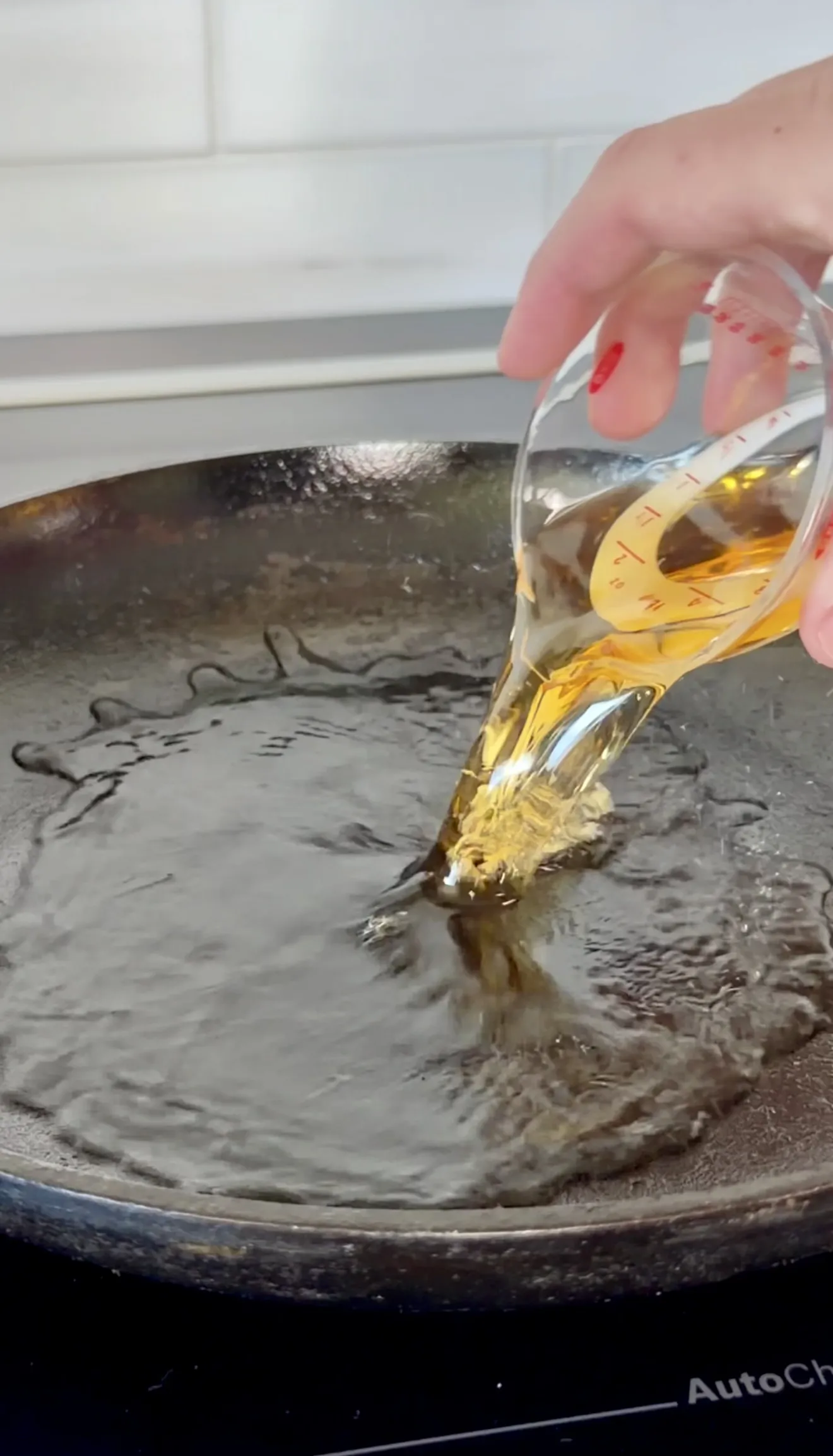 Whiskey being poured into a hot skillet with melted butter
