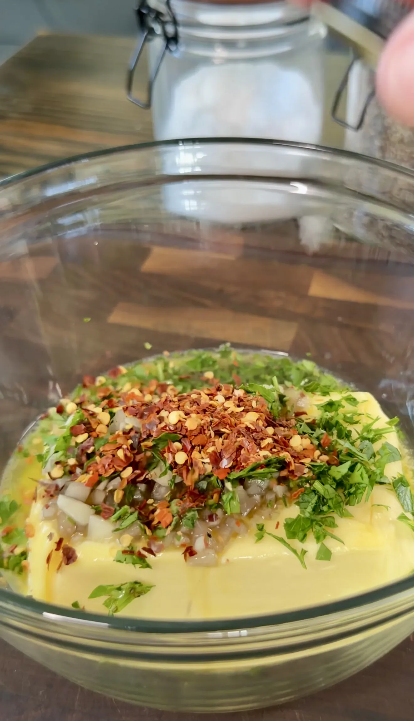 Finished whiskey butter mixture with herbs and spices in a glass bowl
