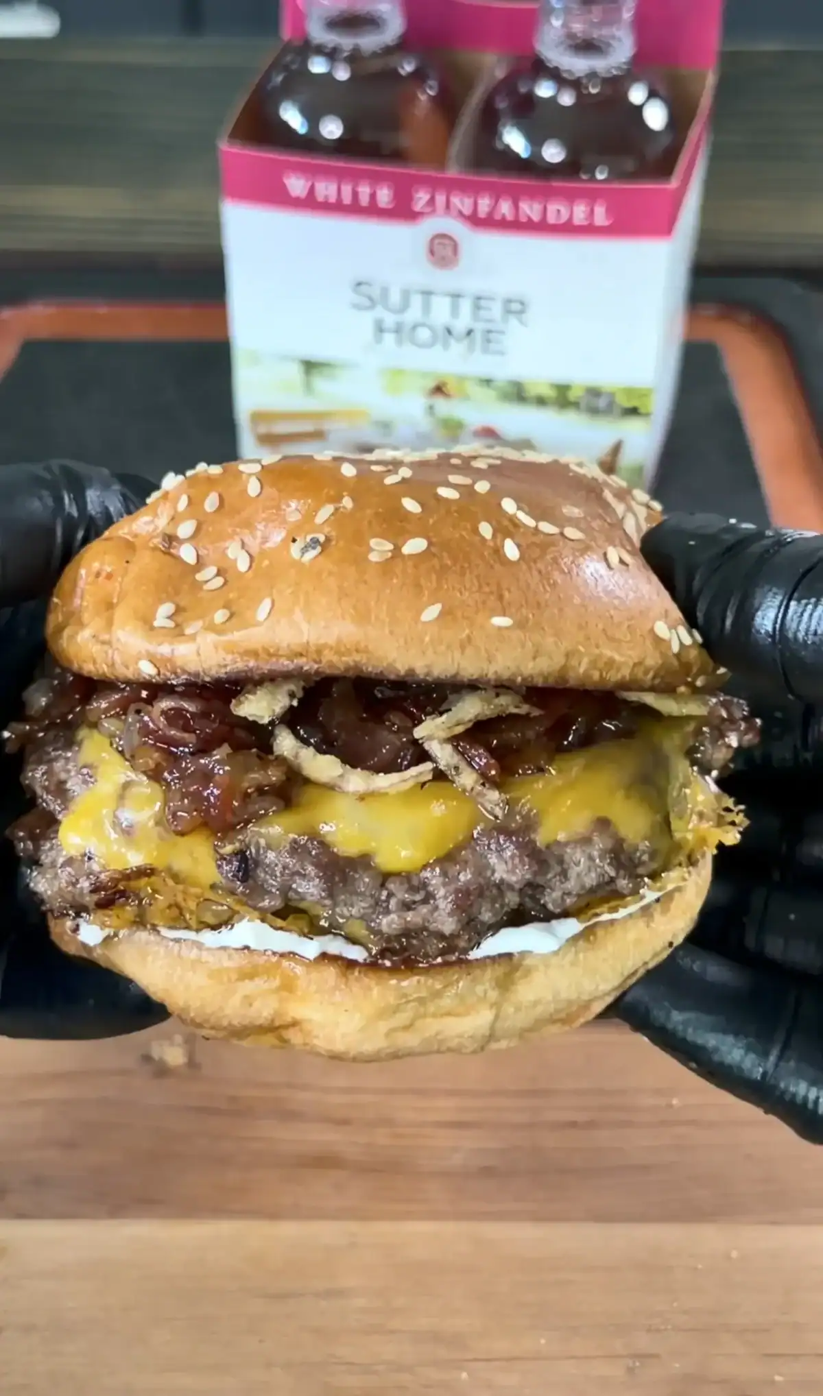 Bacon jam smash burger with melted cheese and caramelized onions on sesame seed bun